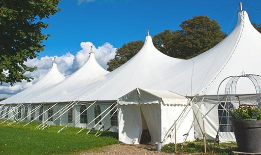 tall green portable restrooms assembled at a music festival, contributing to an organized and sanitary environment for guests in Groton